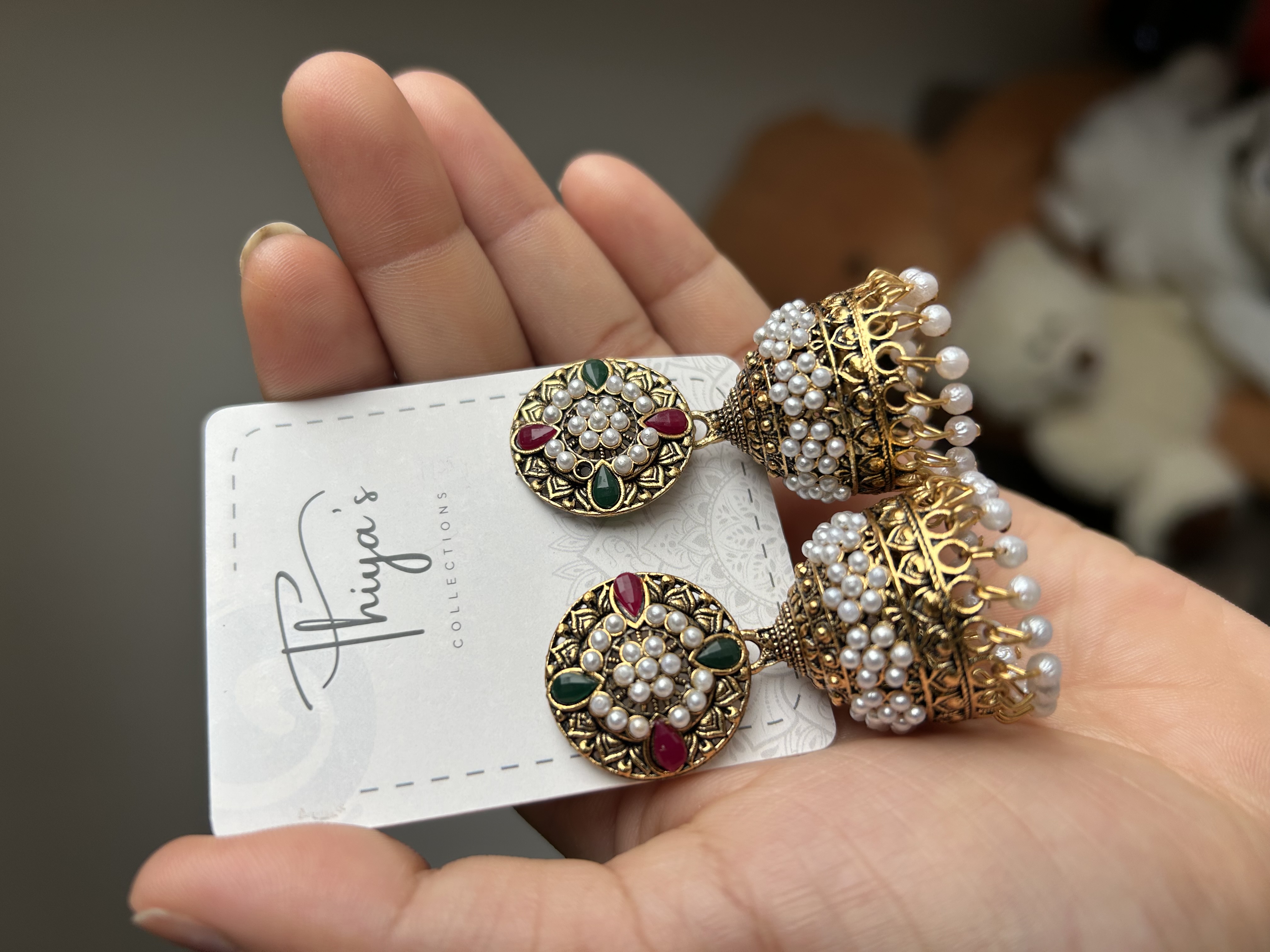 Thiya's Tricolor Pearl Jhumka mit dunklem Gold Finish und geometrischen Gravuren weiße Perlen und grüne rote Tränensteine